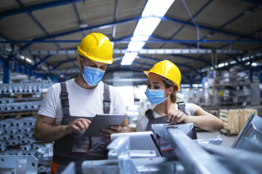 Industrial workers in safety-sensitive roles reviewing compliance procedures at worksite