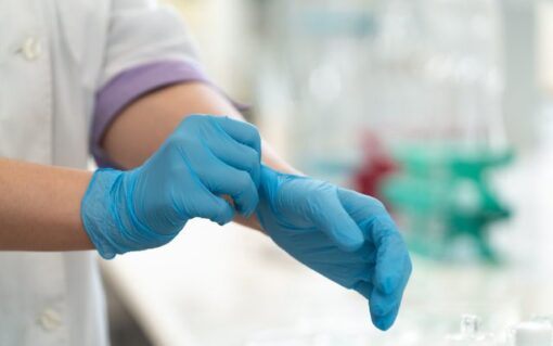 Healthcare specialist putting on disposable gloves for workplace drug awareness month testing